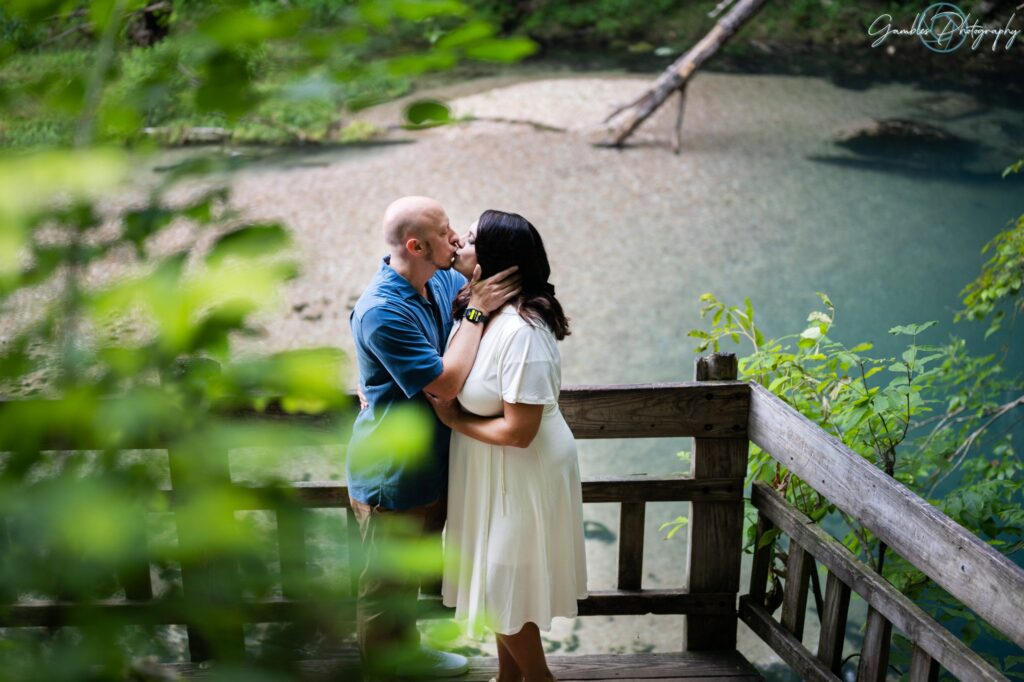 A man holds his partner's face as they kiss during an engagement photo shoot at Ha Ha Tonka State Park. Taken by Gambles Photography