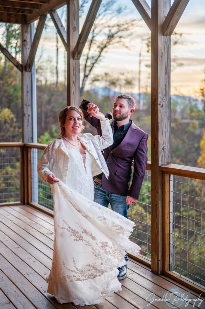 As the orange-blue sunset shines behind them, a groom twirls his bride during their Airbnb wedding. Photo by Gambles Photography