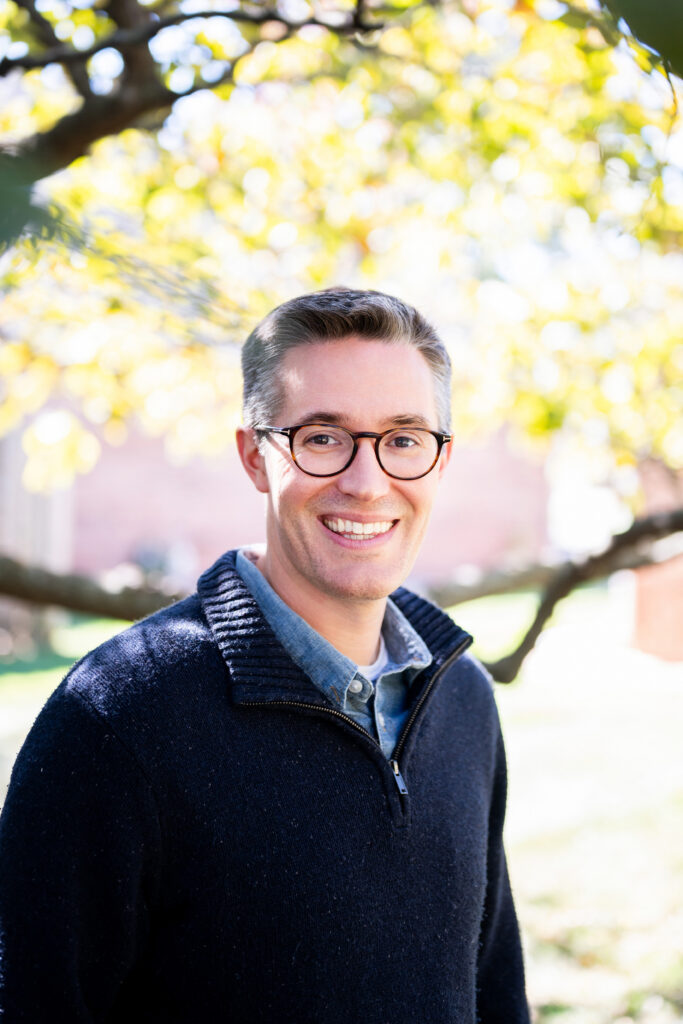 a young man poses outside during headshot photos near Drury University