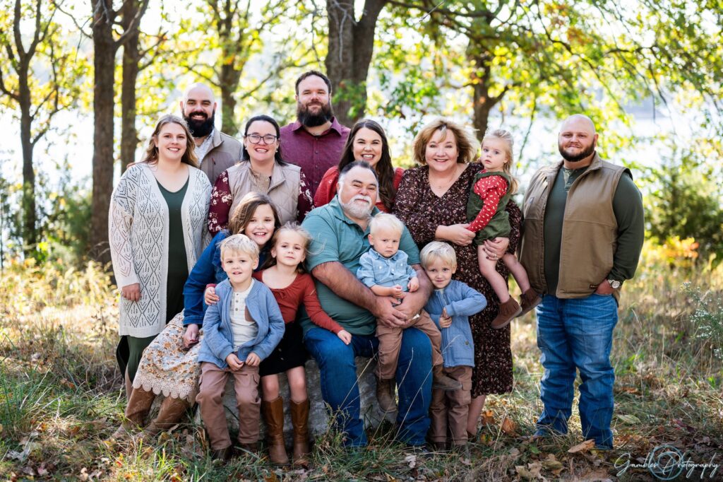 a family stands in the forest at Fellows Lake during a fall photoshoot